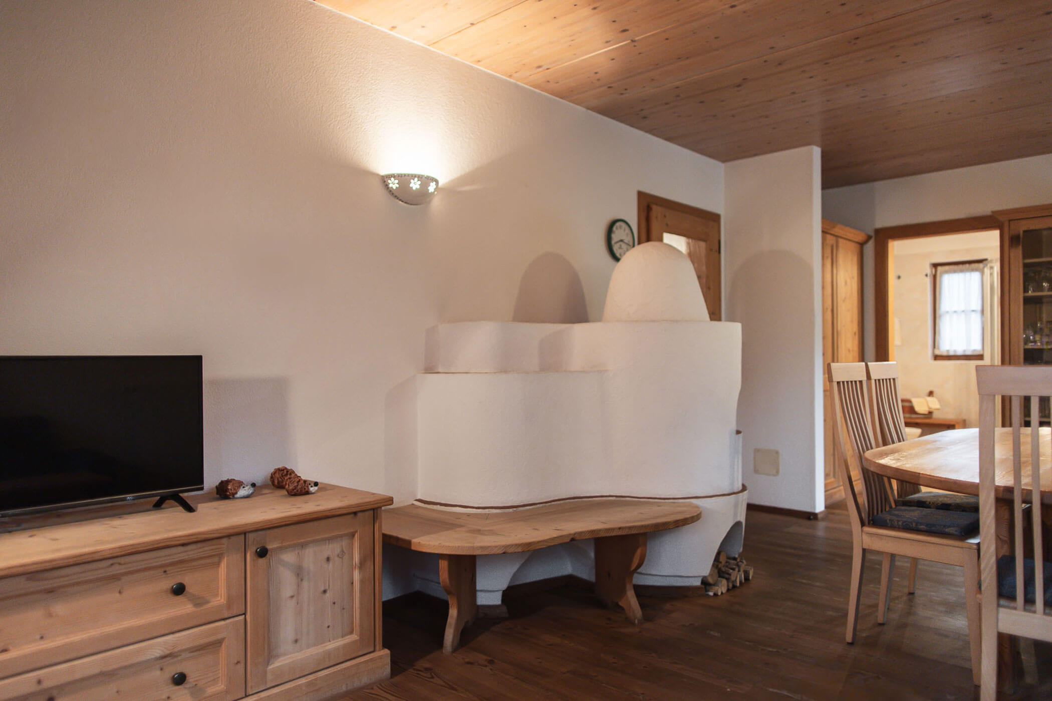 Wohn-Esszimmer mit Esstisch, Ofen und TV in der Ferienwohnung Apfelblüte - Ortnerhof