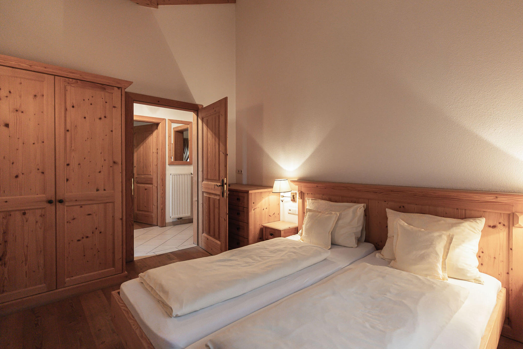 Schlafzimmer mit Doppelbett und Holzschrank in der Ferienwohnung Kirschblüte - Ortnerhof