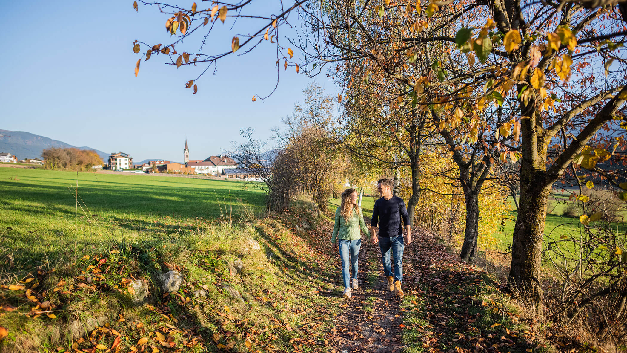 Ein Paar spaziert durch eine herbstliche Landschaft - Ortnerhof